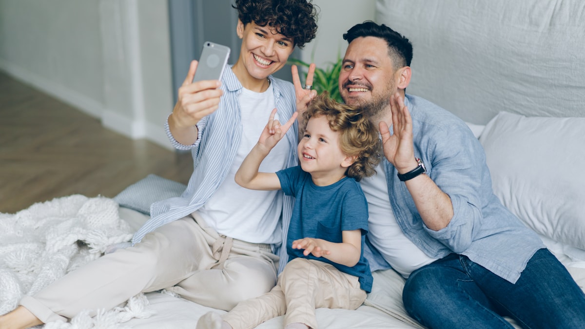 Family of three taking a selfie together with a smartphone