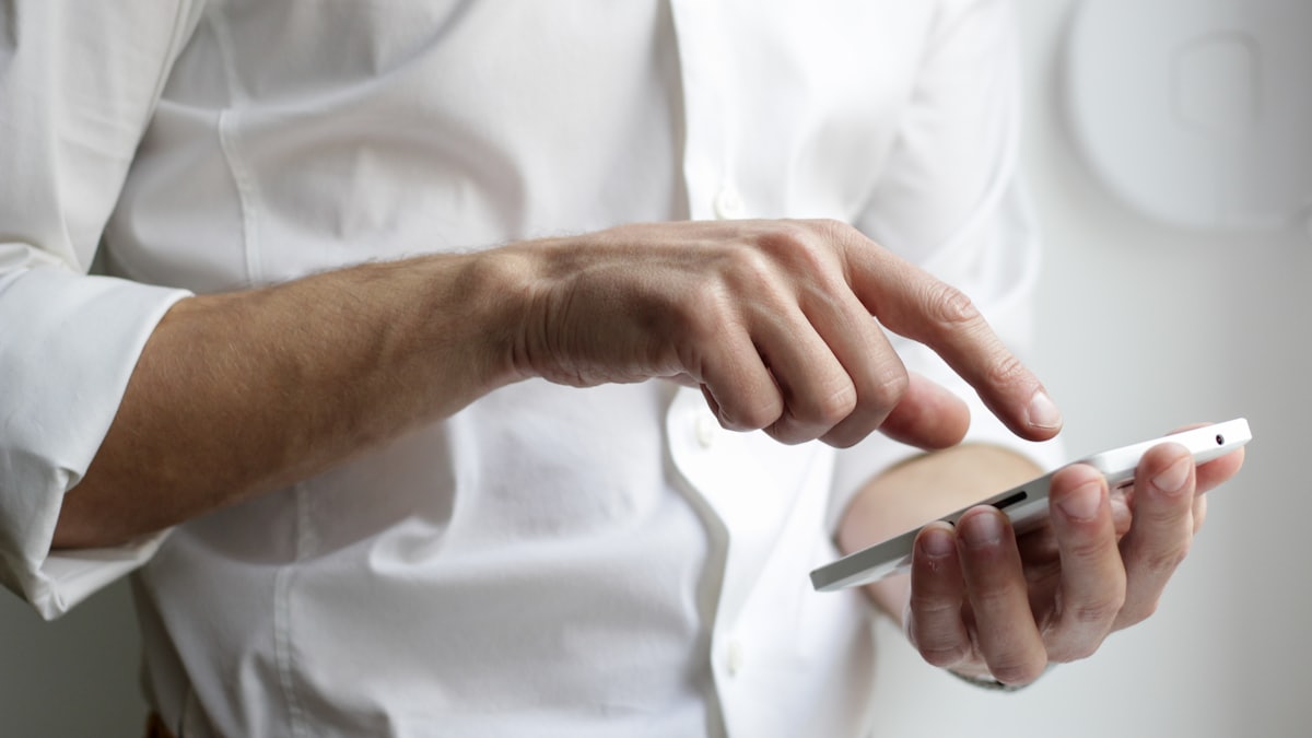 Smartphone on a desk beside a laptop while comparing prepaid and postpaid wireless plans