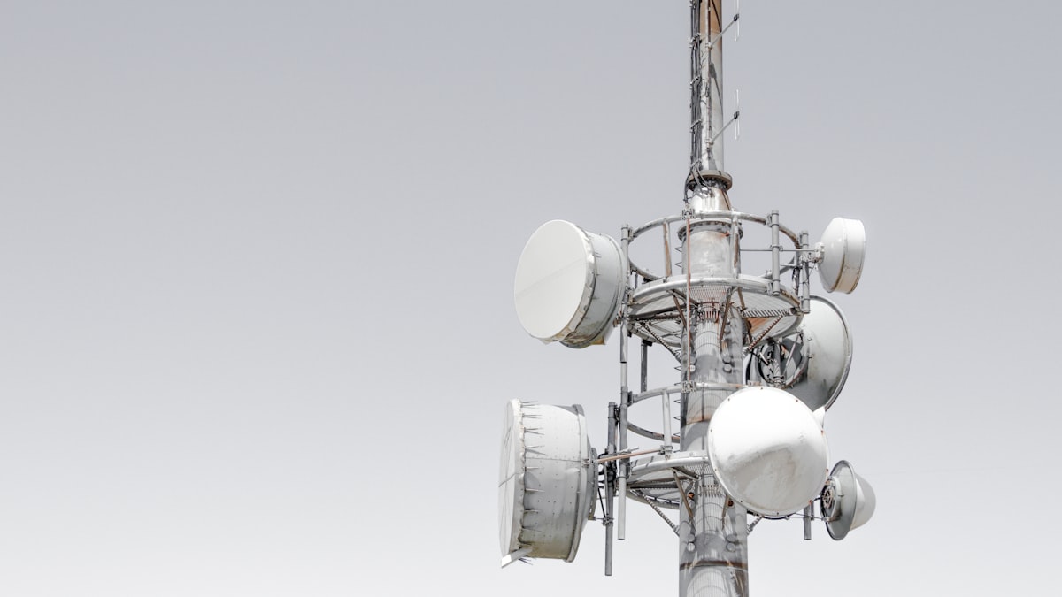 Cellular tower with multiple antenna arrays against a clear sky