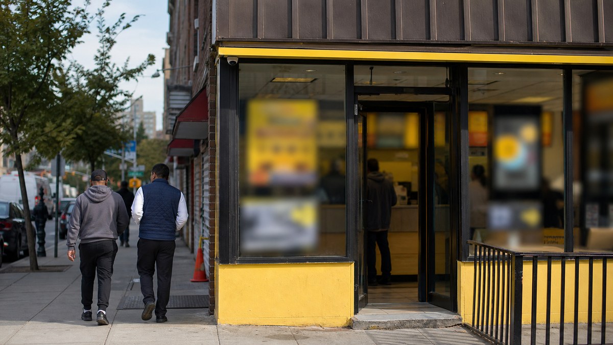 A neighborhood money-transfer storefront with blurred signage, illustrating a wireless plan perk